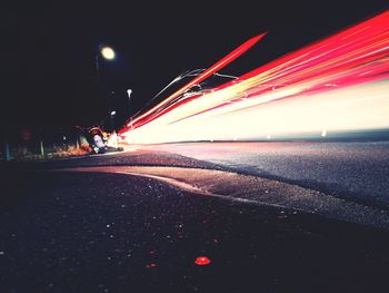 Light trails on road against sky at night