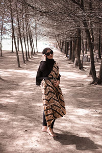 Young woman wearing sunglasses standing on footpath