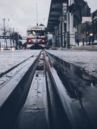 Railroad tracks amidst snow covered city against sky