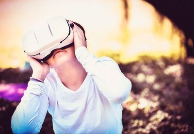 Close-up of boy using virtual reality headset at yard