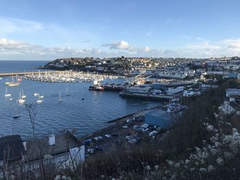 High angle view of sailboats in city by sea against sky