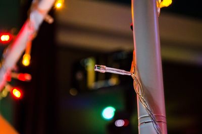 Close-up of illuminated lighting equipment on metal at night