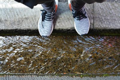 Low section of person standing by gutter