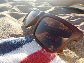 Close-up of sunglasses on sand at beach
