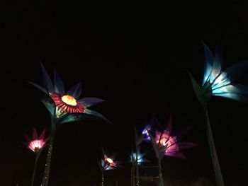 Low angle view of illuminated lights against sky at night