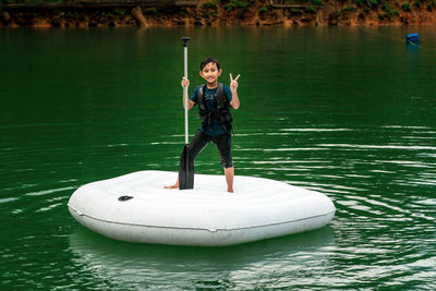 Man holding boat in lake