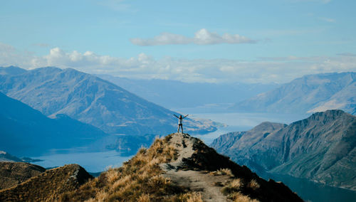 Woman standing on mountains against sky