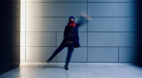 Side view of a man walking on wall