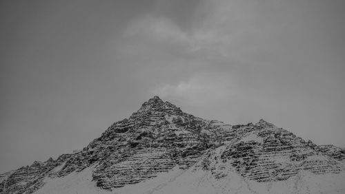 Low angle view of snowcapped mountain against sky