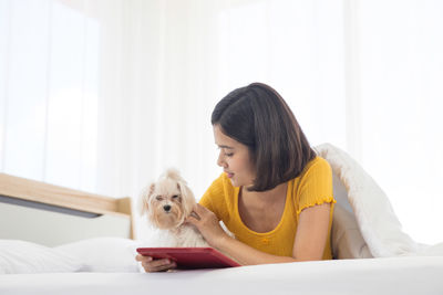 Woman with dog sitting at home