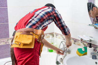 Plumber at work in a bathroom, plumbing repair service, assemble and install concept.