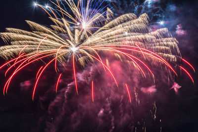 Low angle view of firework display at night