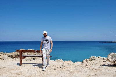 Man standing on beach against clear sky