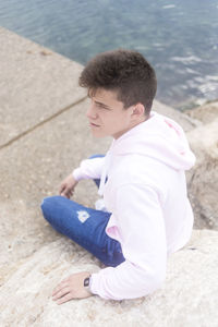 Side view of young man sitting outdoors