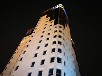 Low angle view of skyscraper against sky at night