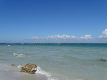 Scenic view of beach and sea against blue sky