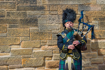 Full length of man standing against wall