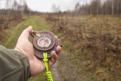 Close-up of hand holding camera on field