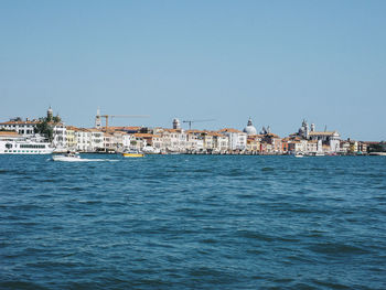 Canal against buildings in city on sunny day