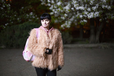 Portrait of woman standing against trees