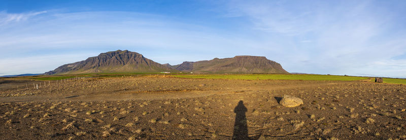 Scenic view of land and mountains against sky