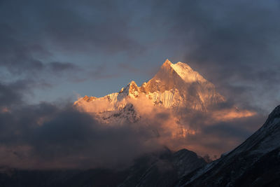 Low angle view of snowcapped mountains against sky during sunset