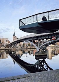 Arch bridge over river against buildings