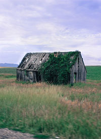 Abandoned house on field against sky