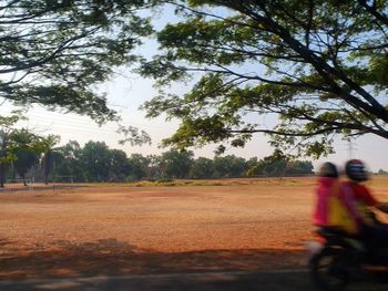 Man riding motorcycle on road against sky