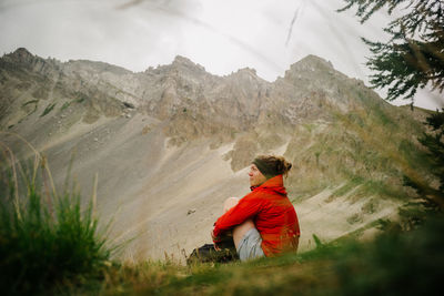 Woman sitting against mountains