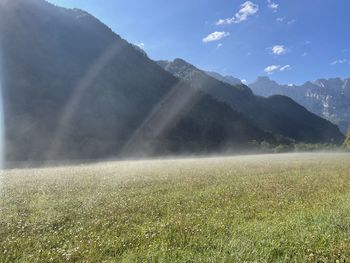 Scenic view of land and mountains against sky