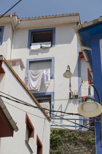 Low angle view of clothes drying on building against sky