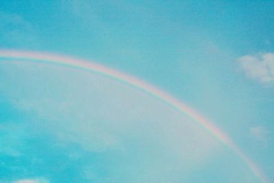 Low angle view of rainbow against blue sky