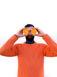 Midsection of man holding camera over white background