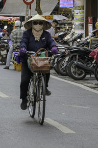 Rear view of man riding bicycles on street