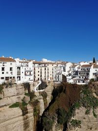 Buildings in city against clear blue sky