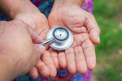 Close-up of person giving woman stethoscope