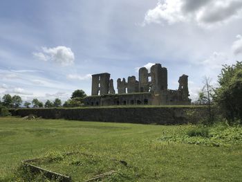 Old ruin building on field against sky