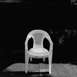 Empty chairs and table against wall