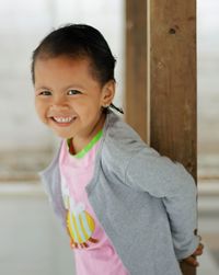 Portrait of young woman standing against wall