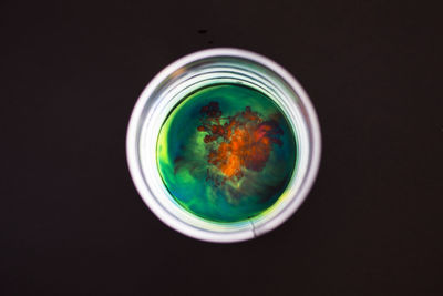 Directly above shot of soup in bowl against black background