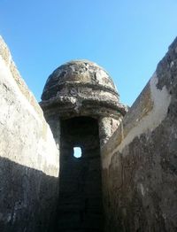 Low angle view of old ruin against clear blue sky