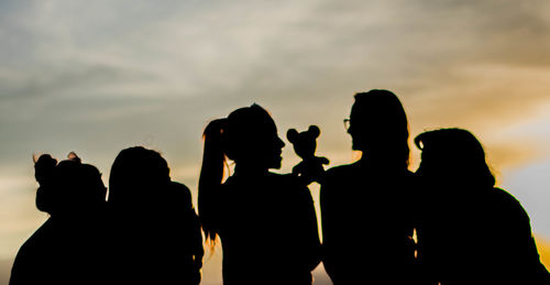 Silhouette people against sky during sunset