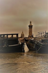 Ship moored in sea against cloudy sky