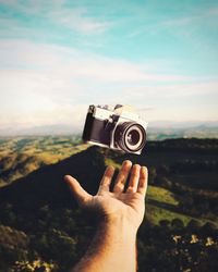 Midsection of person photographing against sky