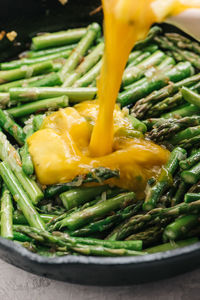 Adding eggs to skillet for asparagus frittata