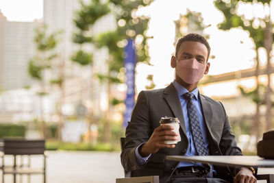 Portrait of businessman using mobile phone in city