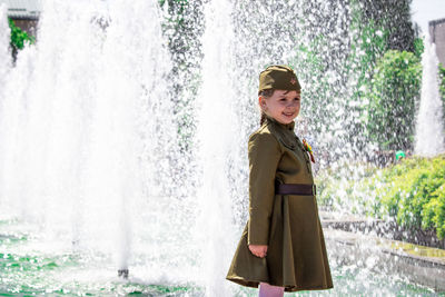 Portrait of woman standing against fountain