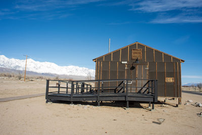 Lifeguard hut on land against blue sky