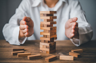 Midsection of businessman playing with toy blocks on table